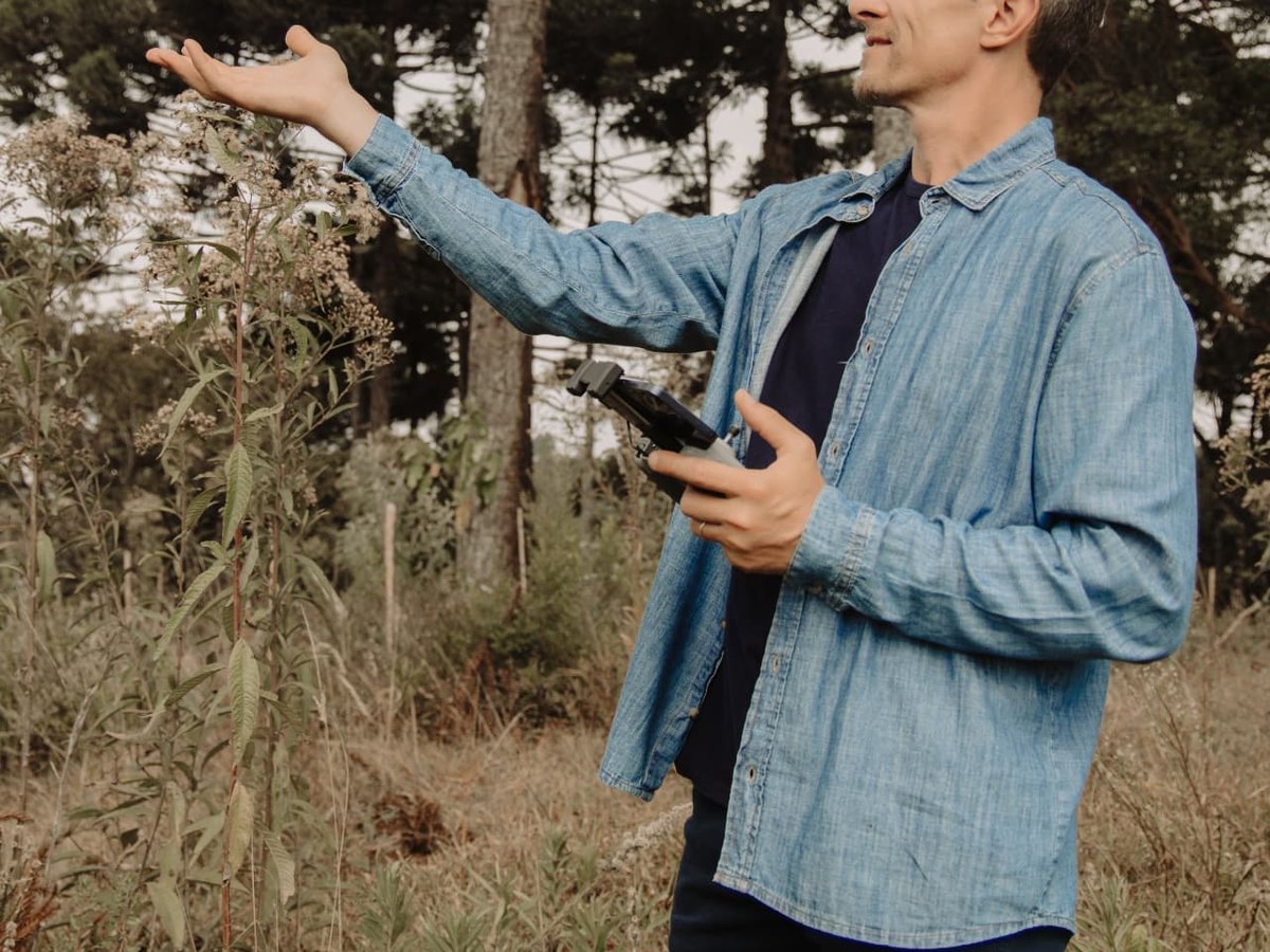Engenheiro florestal medindo o diâmetro de uma árvore durante inventário florestal